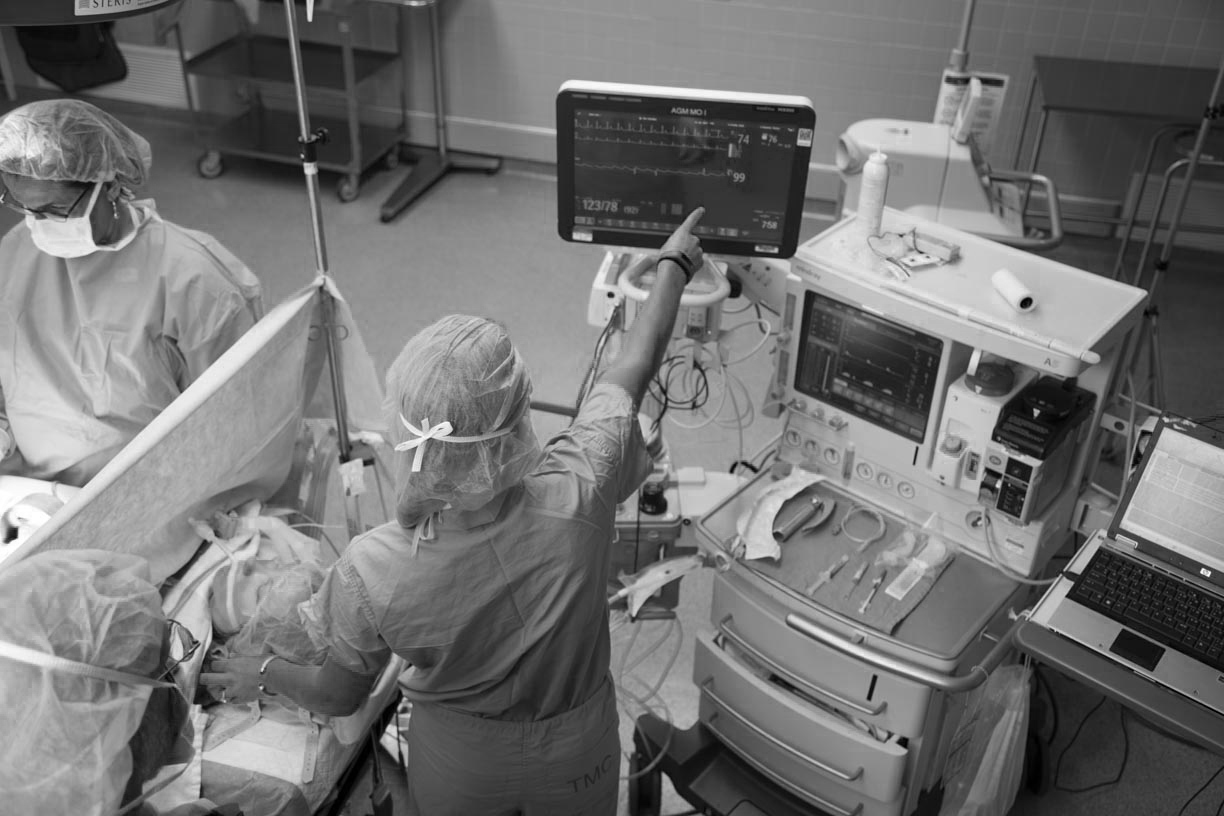 crna nurses performing anesthesia on a patient while looking at monitors of patient performance