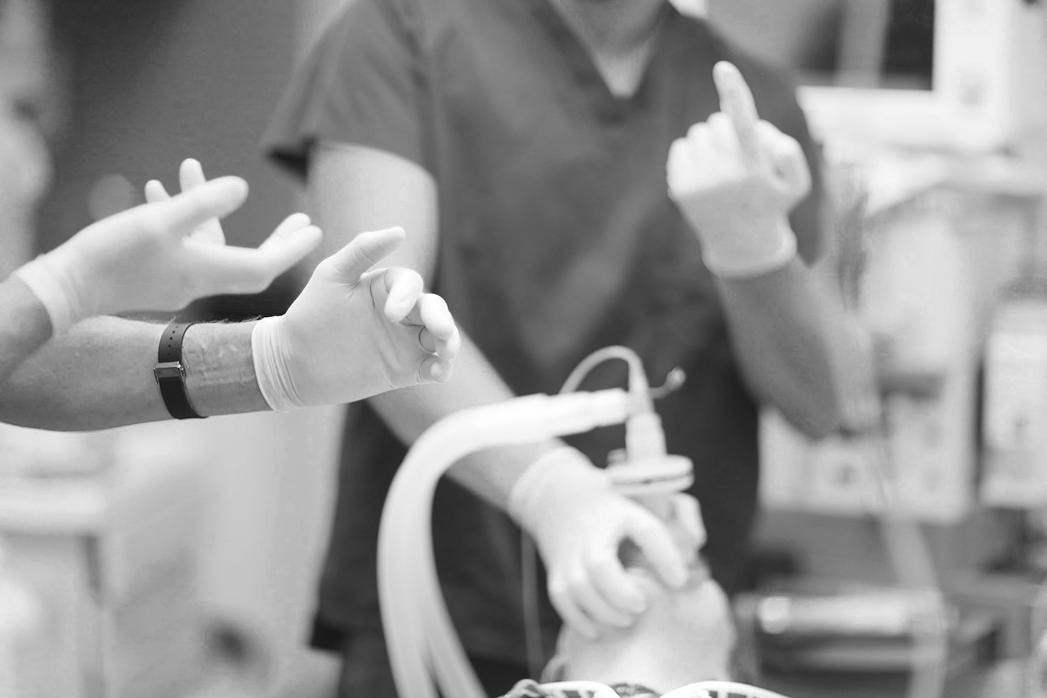 Black and White Nurses talking over patient with ansthesia