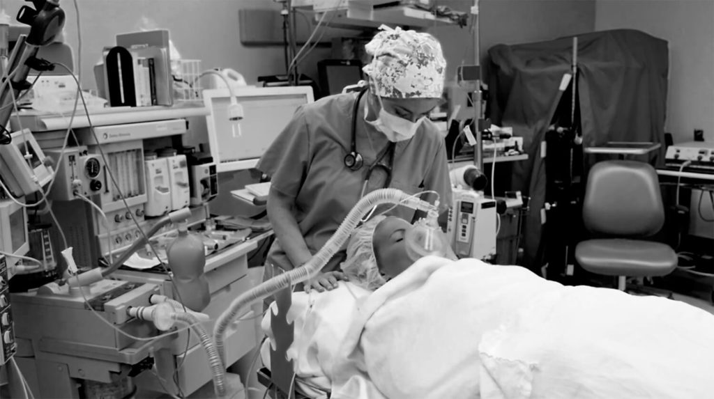 nurse applying anesthesia machine to patient and checking in on patient